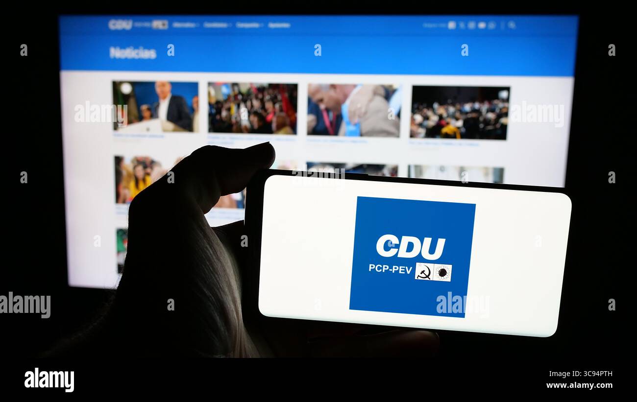 Deutschland. Juli 2025. In dieser Fotoabbildung hält eine Person ein Mobiltelefon mit dem Logo von Coligacao Democratica Unitaria (CDU PCP-PEV) auf dem Bildschirm vor der Webseite. (Credit Image: © Timon Schneider/SOPA Images via ZUMA Press Wire) NUR REDAKTIONELLE VERWENDUNG! Nicht für kommerzielle ZWECKE! Stockfoto