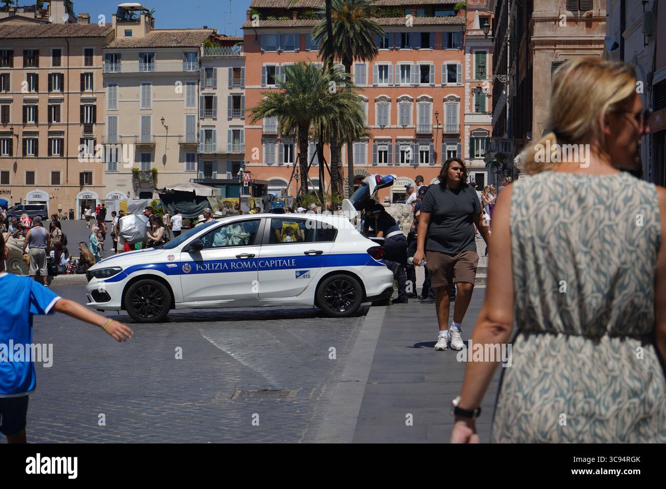 Ein Polizeiauto der Polizia Roma Capitale auf einer überfüllten Piazza di Spagna an einem sonnigen Tag und historische Gebäude überall. Stockfoto