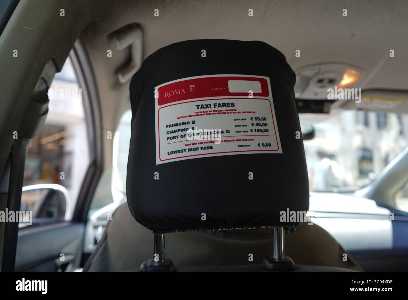 • Auf der Rückseite eines Taxifahrersitzes mit einem Fahrpreisschild mit festen Tarifen für Ziele wie Fiumicino und Ciampino. Stockfoto