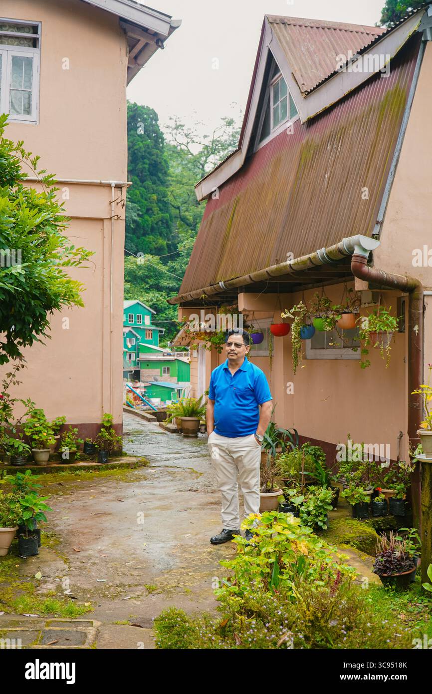 Man steht in einer ruhigen Wohnallee, umgeben von Topfpflanzen und traditionellen Häusern in Darjeeling Hill Station Stockfoto