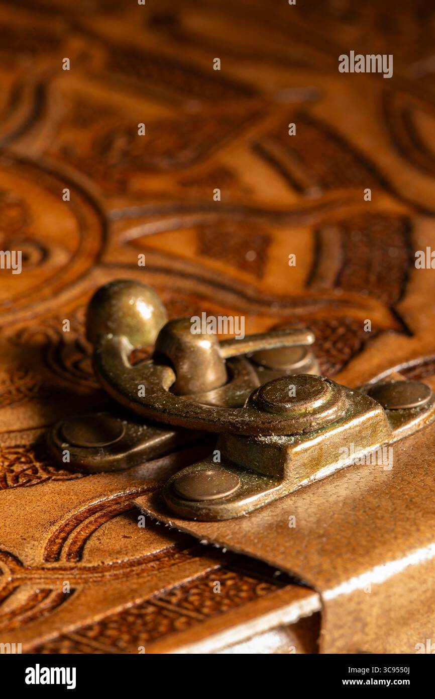 Nahaufnahme eines Metallverschlusses auf einem alten geprägten Lederjournal-Hintergrund. Stockfoto