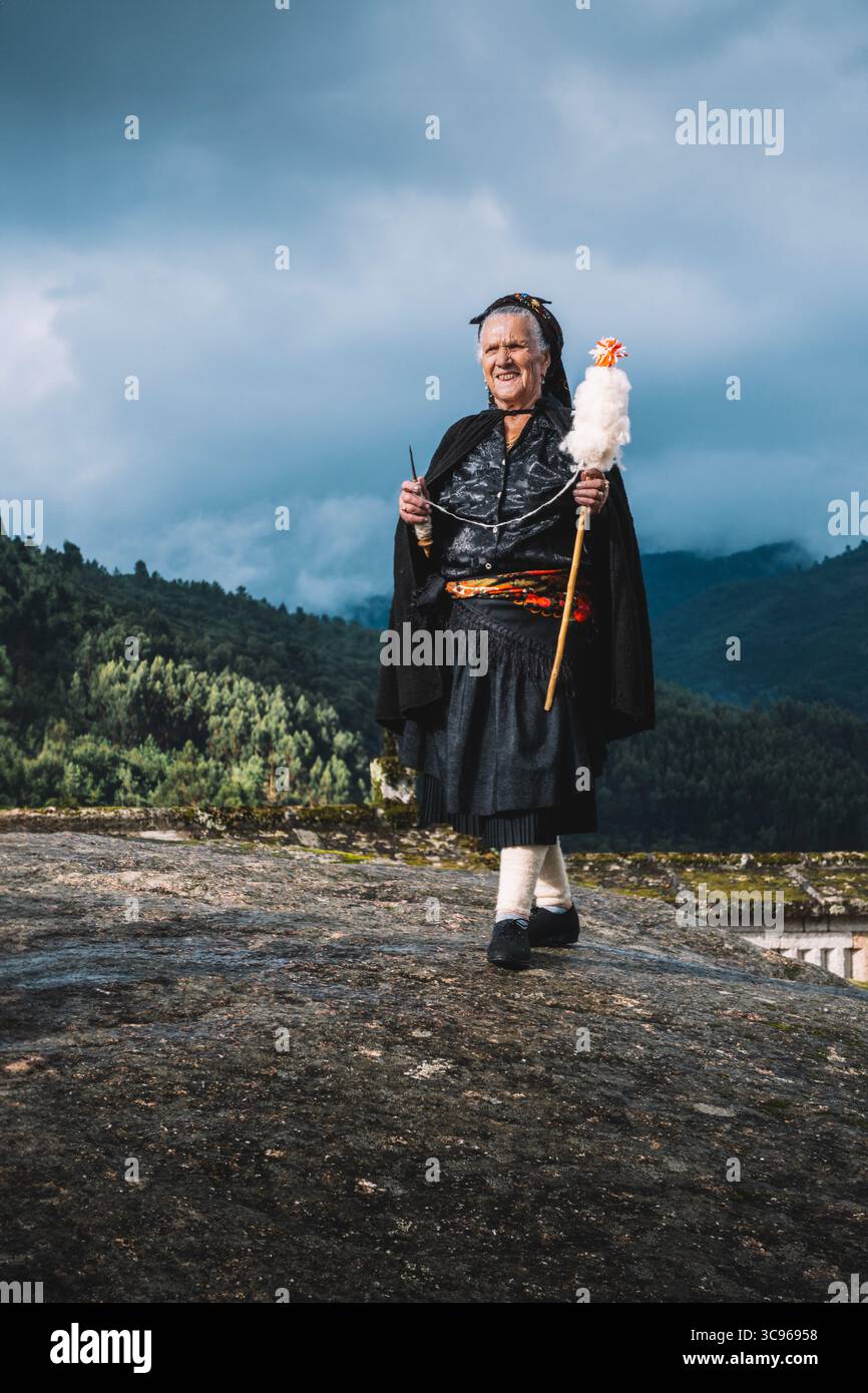 Ein traditionelles portugiesisches „Fiadeira“ wird von den alten Steinkammern „espigueiros“ in Soajo, Region Minho, Portugal, gefangen Stockfoto