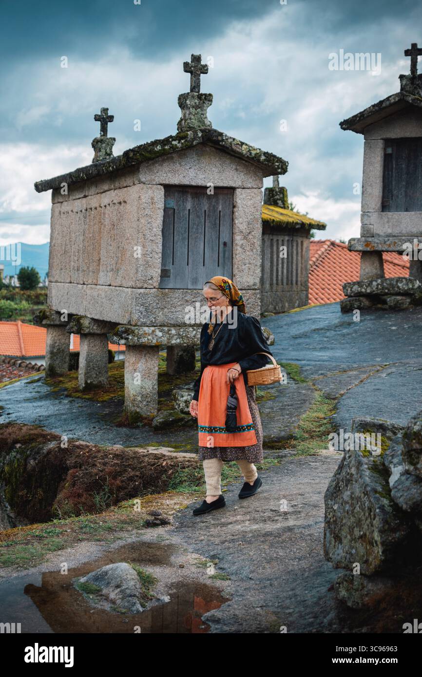 Portugiesin, eine Fiadeira, spaziert durch alte Steinspeicher in Soajo. Minho, Ältere Frau, Ländliches Dorf, Kulturell, Traditionell Stockfoto