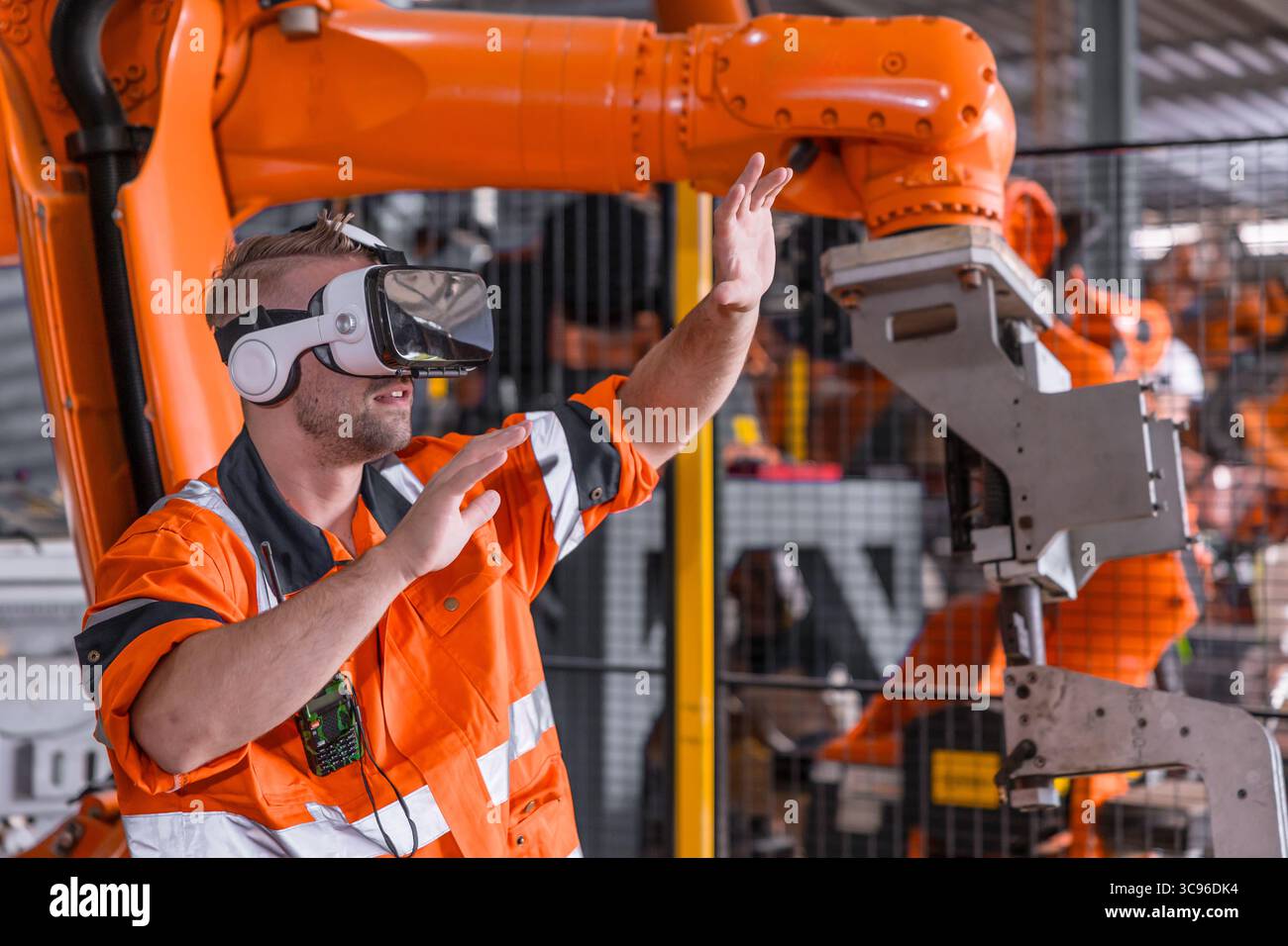 Ingenieur männlich mit VR Virtual-Reality-Brille-Headset-Gerät zur Steuerung des Roboterarms in der modernen Technologiebranche Stockfoto