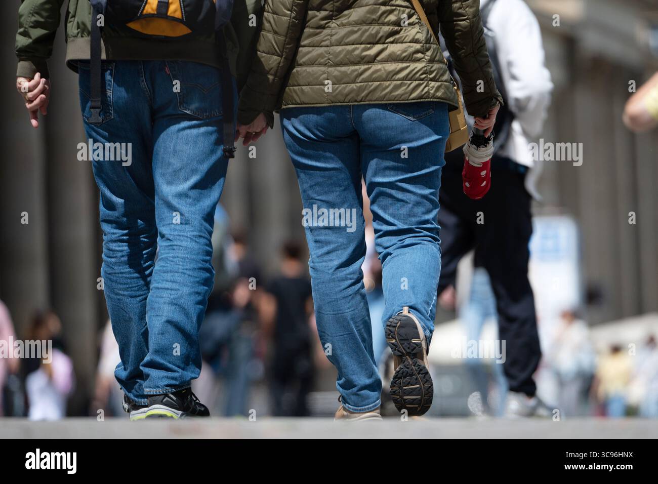 Stuttgart, Deutschland. August 2025. Zwei Personen gehen Hand in Hand durch die Fußgängerzone in Stuttgart. Andere Passanten sind im Hintergrund zu sehen. Quelle: Markus Lenhardt/dpa/Alamy Live News Stockfoto