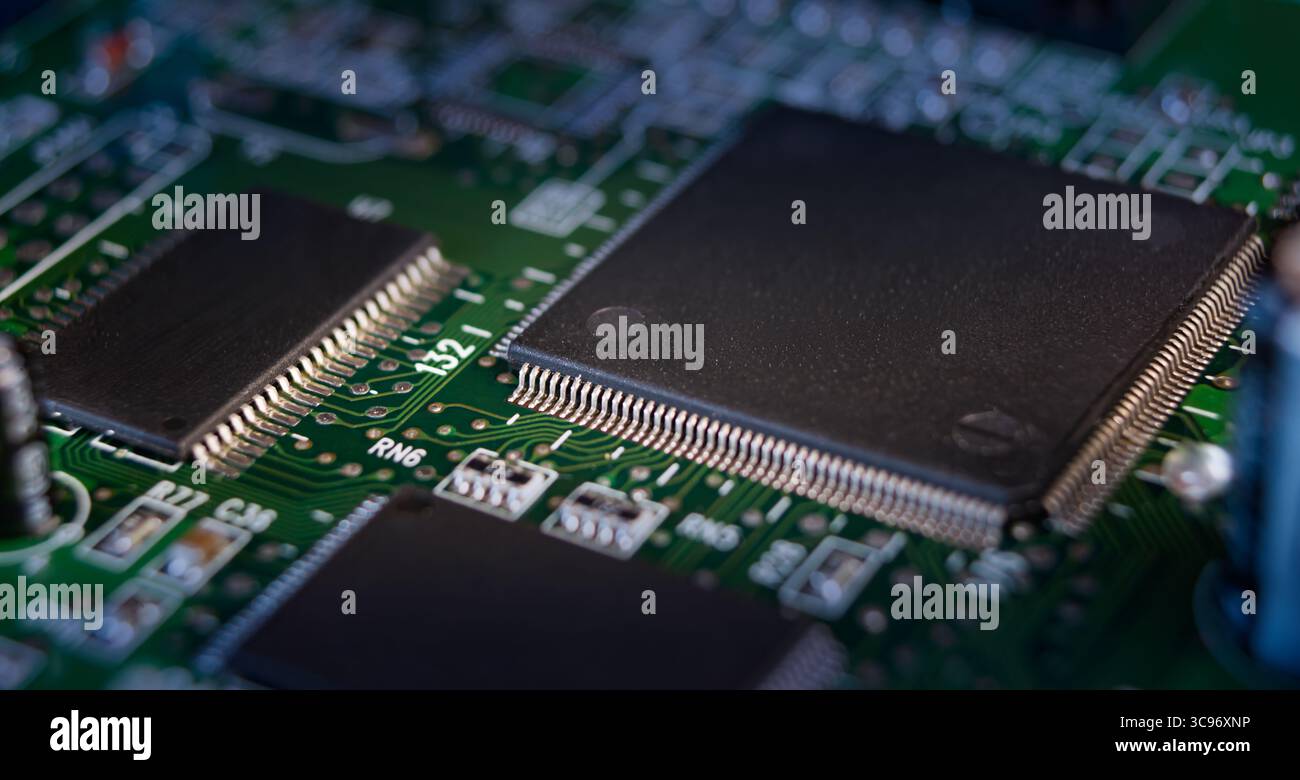 In einer Nahansicht werden detaillierte Komponenten einer Leiterplatte erfasst, wobei Verbindungen und Mikrochips auf einer grünen Oberfläche hervorgehoben werden. Stockfoto