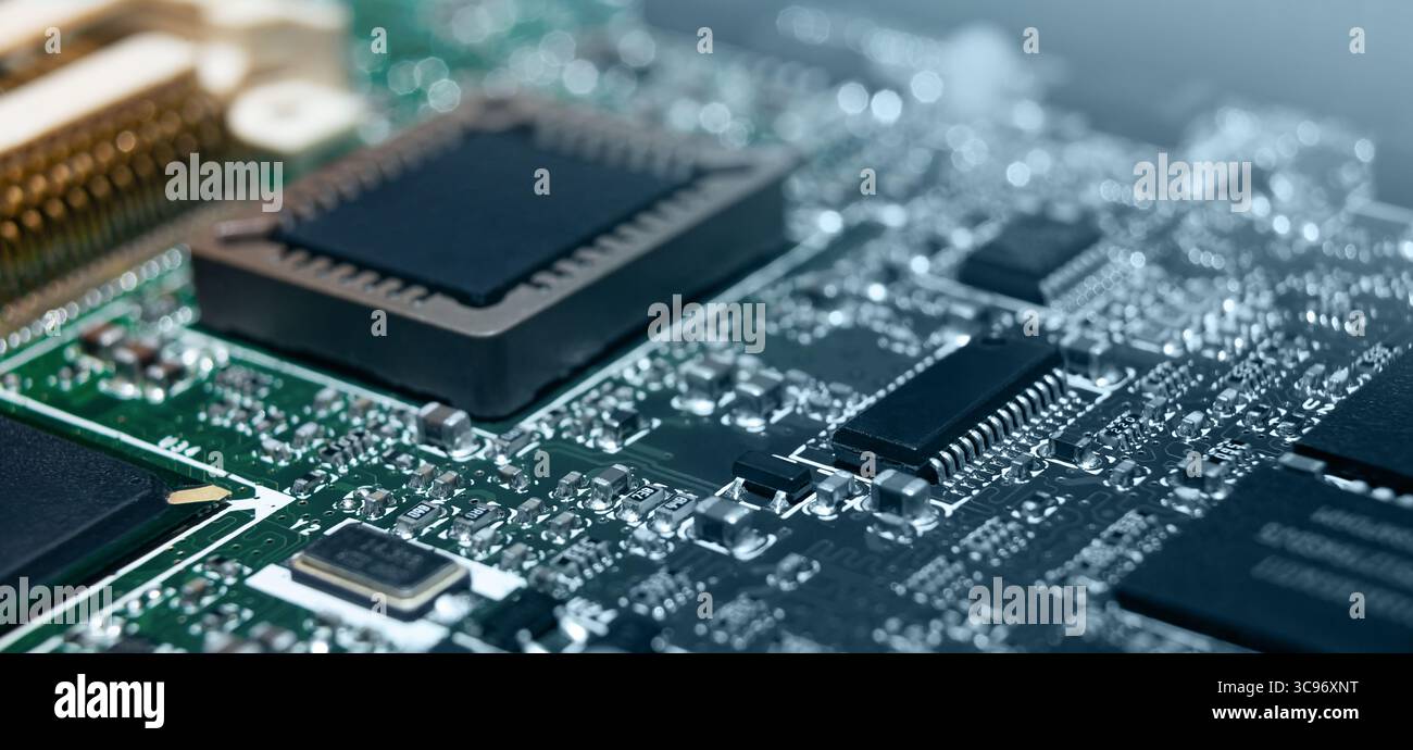 Bei der detaillierten Inspektion werden fein geätzte Schaltungen und verschiedene elektronische Komponenten auf einer modernen Leiterplatte entdeckt. Stockfoto