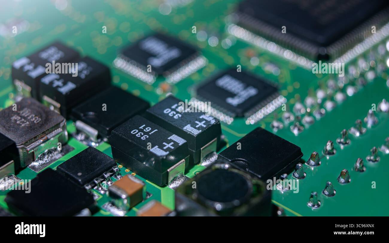 Detaillierte Ansicht einer elektronischen Leiterplatte mit mehreren Komponenten, Widerständen und integrierten Schaltungen, die für moderne Geräte typisch sind. Stockfoto