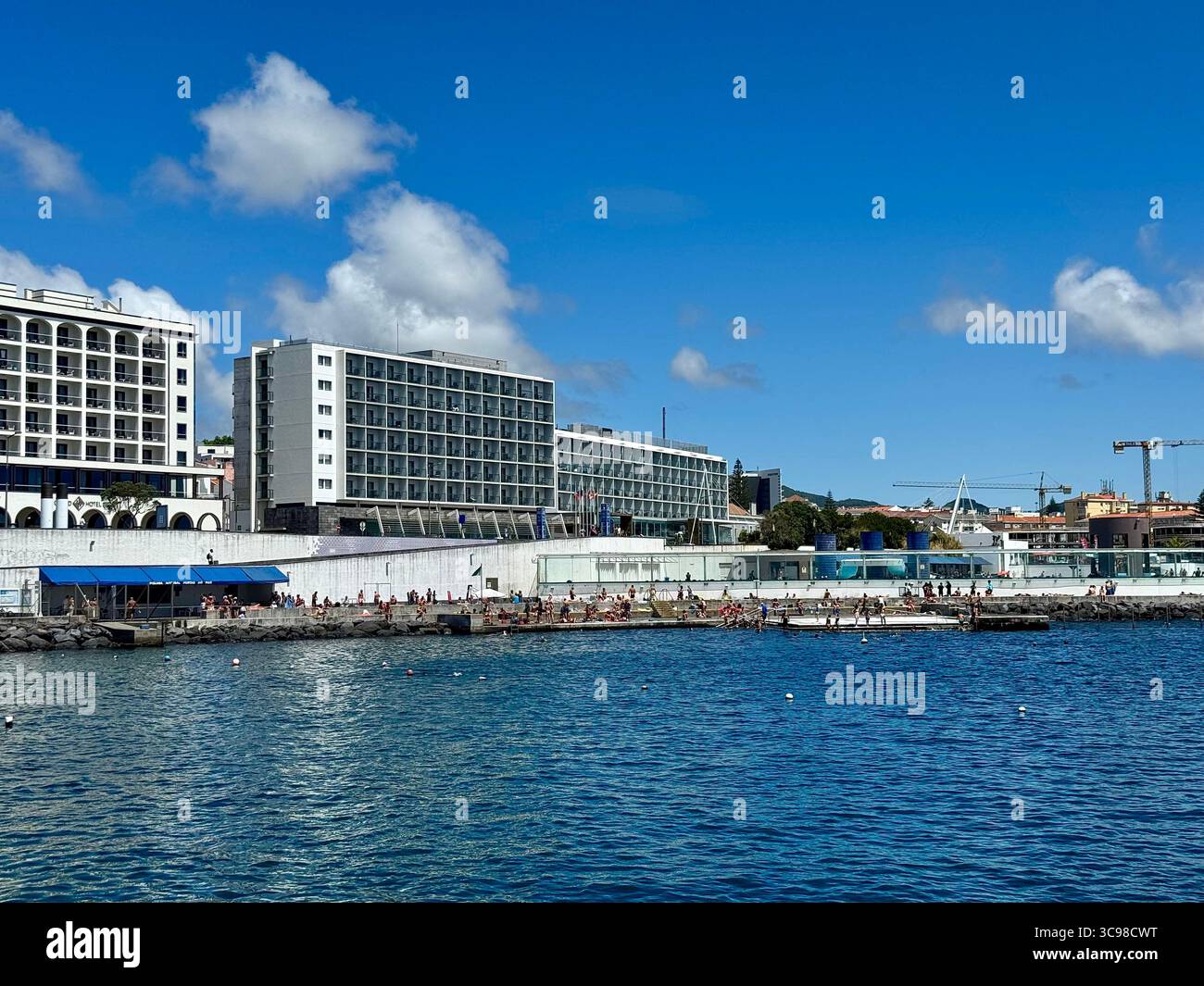 Hotels am Meer und Naturbadegebiet entlang der Küste von Ponta Delgada, Insel São Miguel, Azoren, Portugal, an einem sonnigen Sommertag. - Smartphone-aufgenommenes Stockfoto