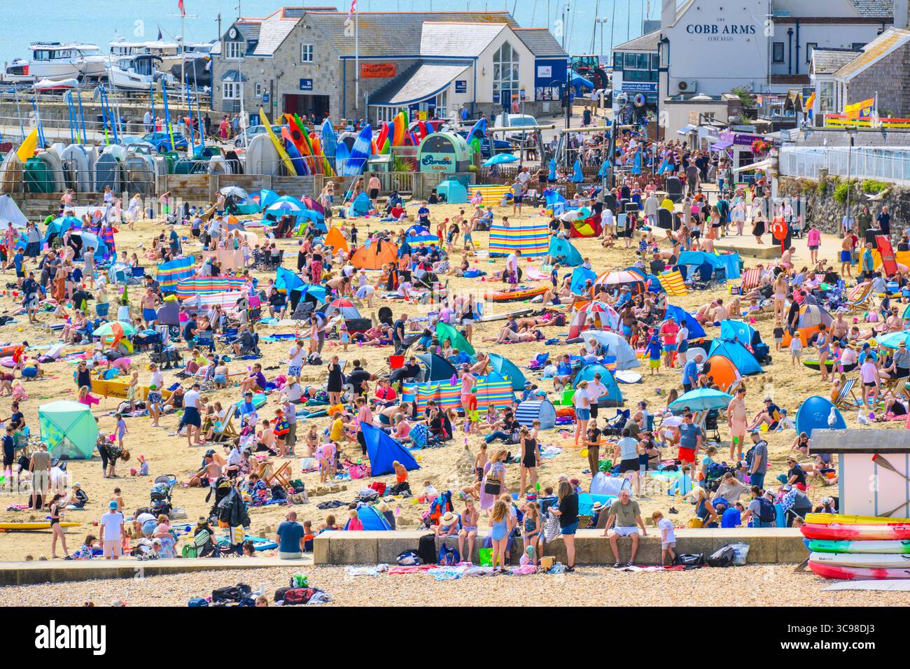 Lyme Regis, Dorset, Großbritannien. August 2025. Wetter in Großbritannien: Urlauber strömten in den Badeort Lyme Regis, um die glühend heiße Sonne während der Schulferien zu genießen. Der Strand war voll von Familien und Sonnenanbetern, die die Rückkehr des heißen und sonnigen Wetters nach der kürzlichen Phase des nassen und windigen Wetters begrüßten. Quelle: Celia McMahon/Alamy Live News Stockfoto