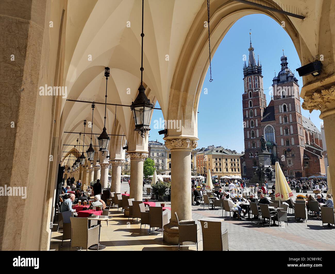 Krakaus Hauptplatz, bekannt als Rynek Główny, mit den Bögen der Tuchhalle Sukiennice und den Doppeltürmen der Marienkirche. - Smartphone-aufgenommenes Stockfoto
