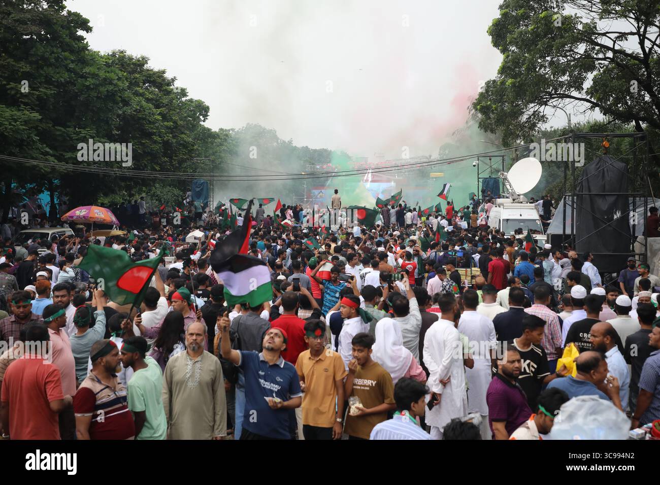 Menschen halten Bangladeschs Nationalflagge, während sie am 5. August 2025 während des „Juli-Aufstands“ in Dhaka, Bangladesch, feiern. Bangladeschs Interimsführer am 5. August feierte den einjährigen Jahrestag seit dem Sturz des autokratischen Regimes von Scheich Hasina, indem er die Menschen aufforderte, die "Chance" der Reform zu ergreifen. Stockfoto