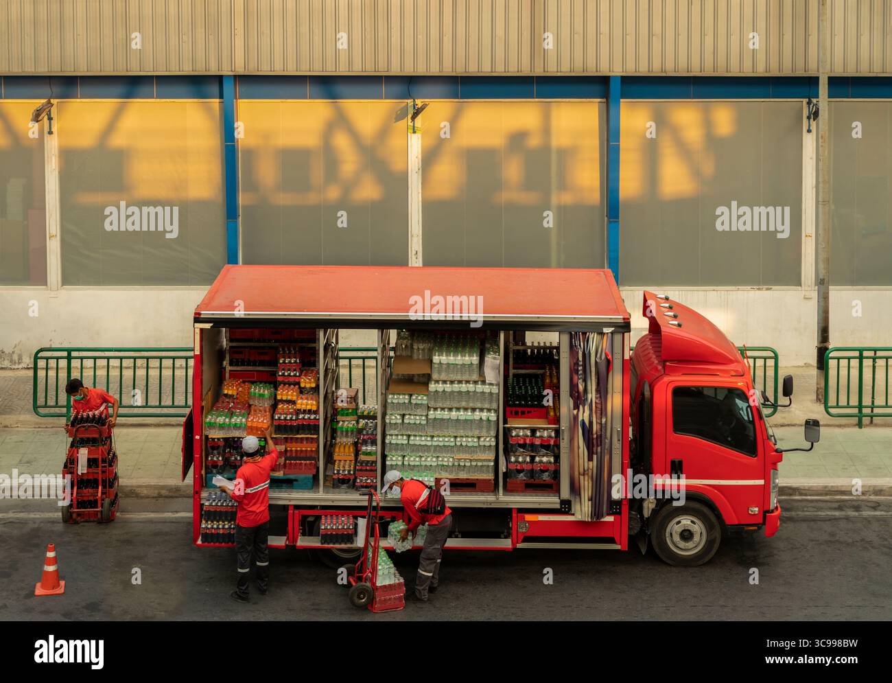 LKW-Fahrer Lieferung gut, Abladen LKW trägt Gesichtsmaske während Corona Virus Pandemie in Bangkok. Servicebereitstellung. Stockfoto