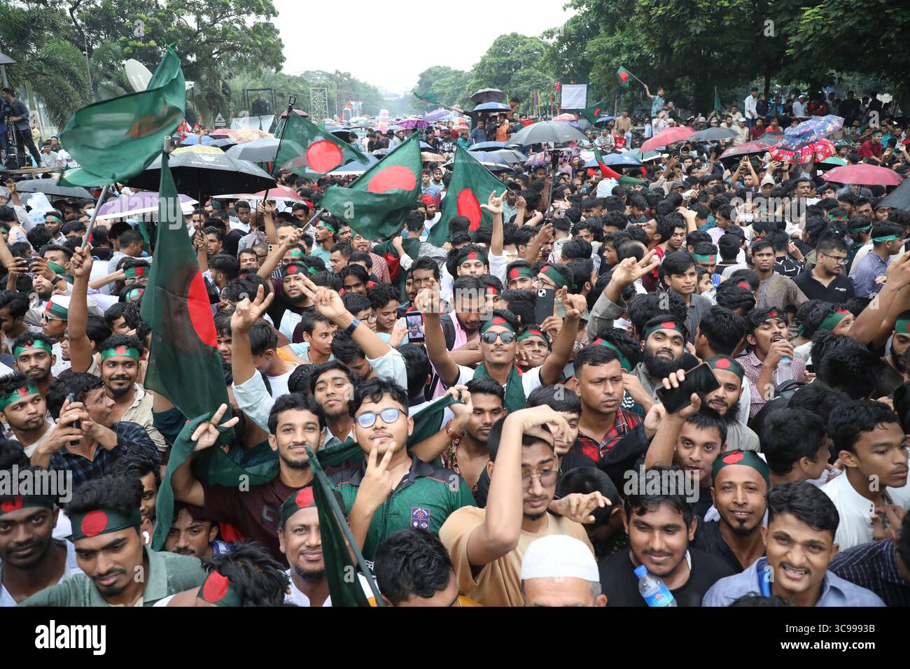 Menschen halten Bangladeschs Nationalflagge, während sie am 5. August 2025 während des „Juli-Aufstands“ in Dhaka, Bangladesch, feiern. Bangladeschs Interimsführer am 5. August feierte den einjährigen Jahrestag seit dem Sturz des autokratischen Regimes von Scheich Hasina, indem er die Menschen aufforderte, die "Chance" der Reform zu ergreifen. Stockfoto