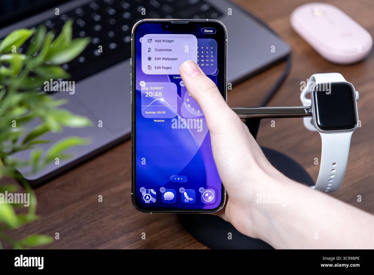 Poznan, Polen – 29. Juli 2025: Mobile iOS 26-Plattform auf einem iPhone, wobei die Hand eines Benutzers interagiert, um Widgets und Liquid Glass-Anwendung anzupassen Stockfoto