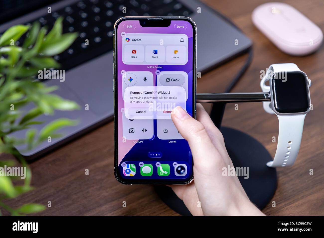 Posen, Polen – 29. Juli 2025: Die Hand einer Person interagiert mit einem Apple iPhone und zeigt den Entfernungsprozess des Gemini Widgets mit ios 26 Liquid Glass int Stockfoto