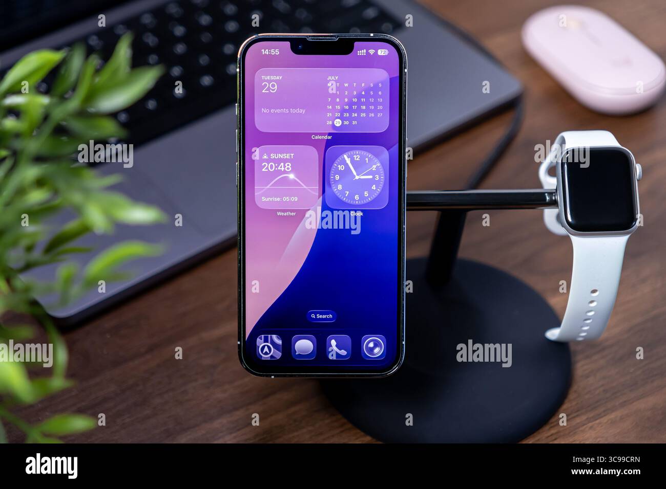 Poznan, Polen – 29. Juli 2025: Visualisierung von ios 26 Liquid Glass auf einem iPhone und Demonstration eines modernen Smart-Device-Setups für vernetzte Produktivität Stockfoto