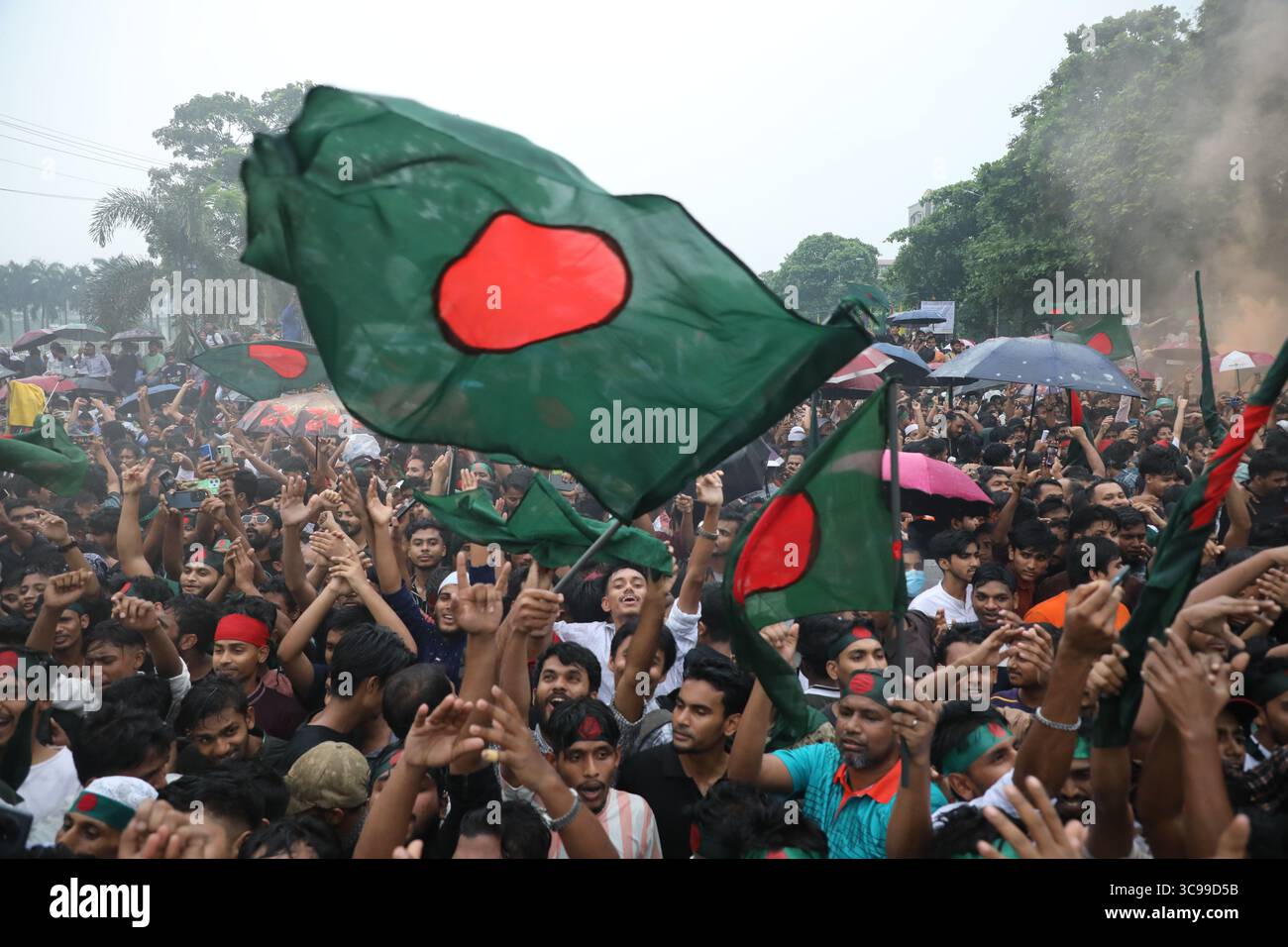 Menschen halten Bangladeschs Nationalflagge, während sie am 5. August 2025 während des „Juli-Aufstands“ in Dhaka, Bangladesch, feiern. Bangladeschs Interimsführer am 5. August feierte den einjährigen Jahrestag seit dem Sturz des autokratischen Regimes von Scheich Hasina, indem er die Menschen aufforderte, die "Chance" der Reform zu ergreifen. Stockfoto