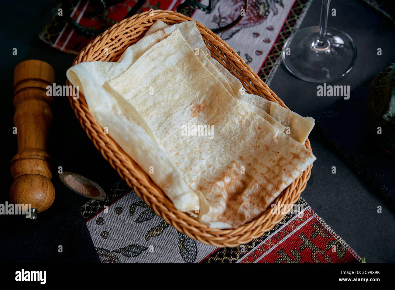Eine Nahaufnahme eines traditionellen Korbs gefüllt mit frisch zubereiteten Fladenbroten, perfekt für ein köstliches Essen Stockfoto