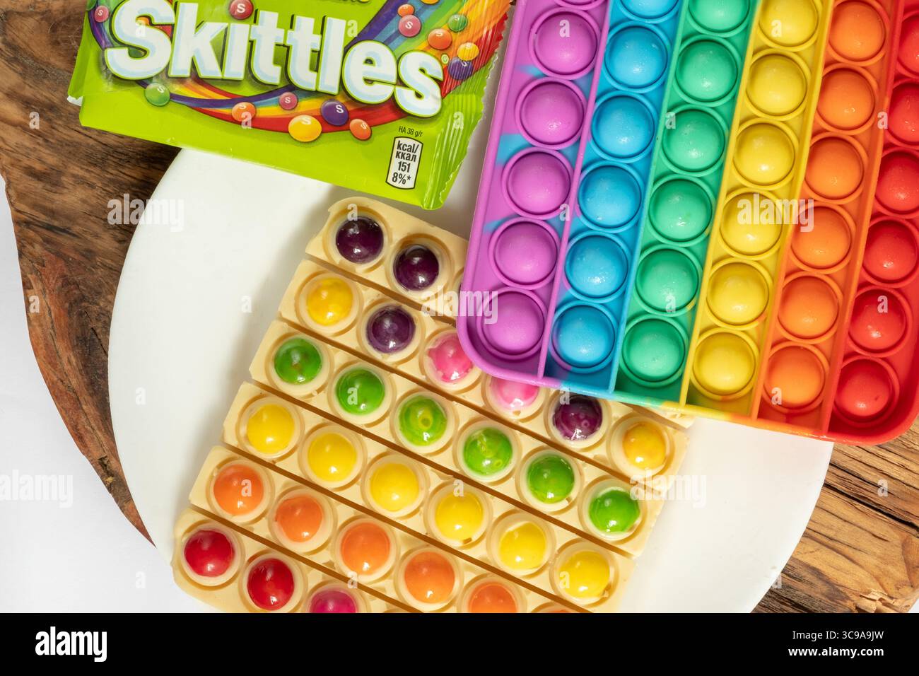 Leben hack. Verwenden Sie das beliebte Pop IT-Spielzeug als Schokoladenform. Weiße Schokolade und bunte Süßigkeiten Stockfoto