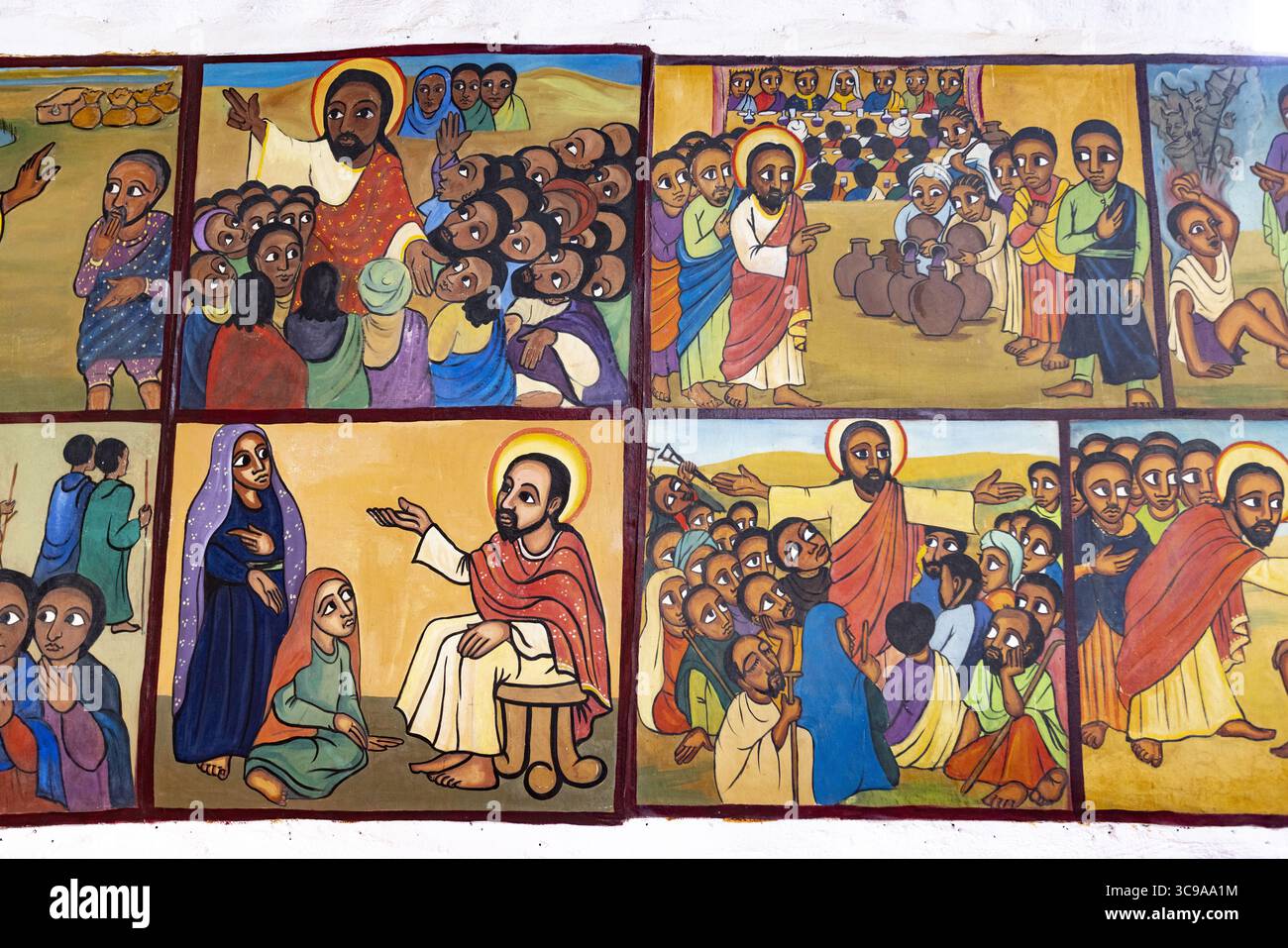 Kalacha, Kenia - 12. Mai 2022: Blick auf lebendige religiöse Wandbilder mit biblischen Szenen, Figuren in kräftigen Farben vor warmen Hintergründen, die alte Geschichten durch eine moderne Linse erzählen. Stockfoto