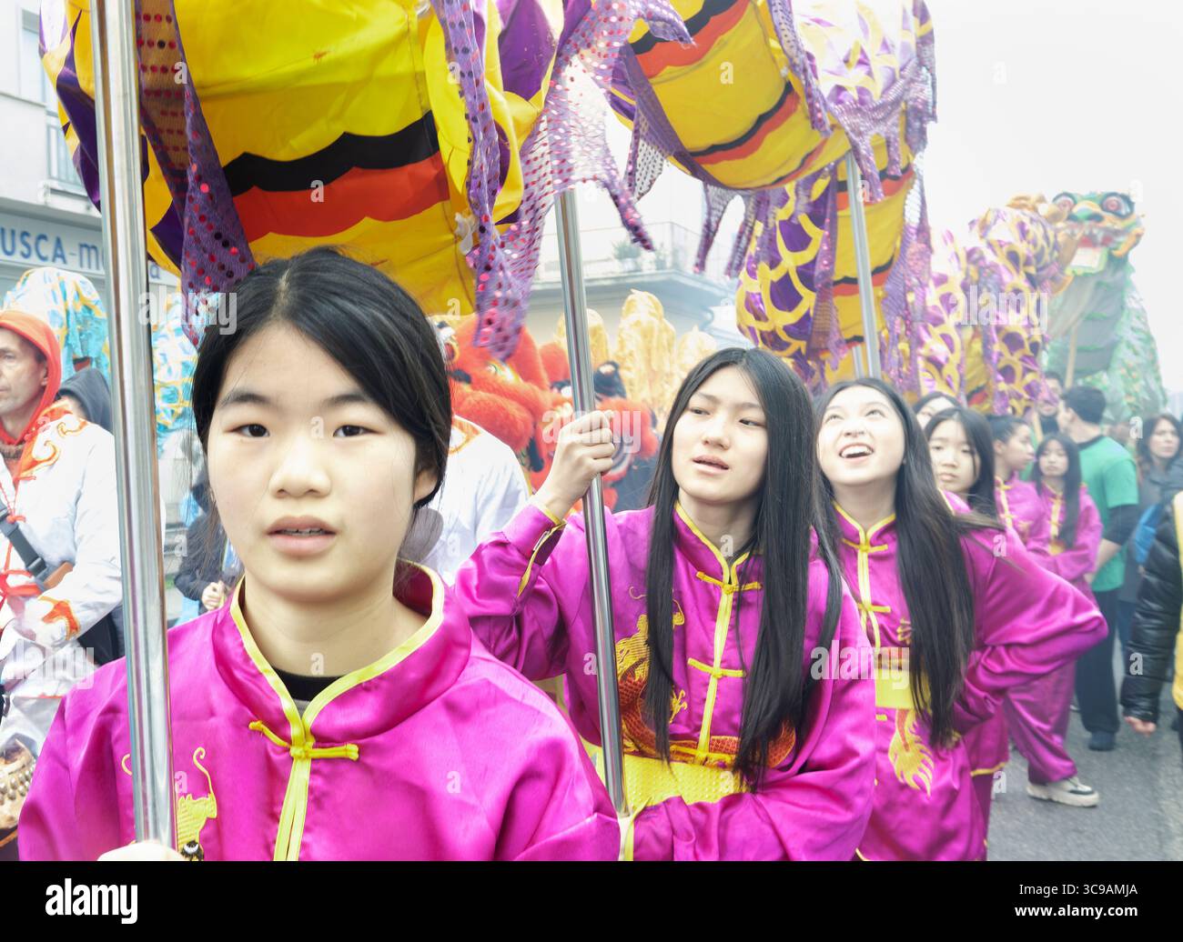 Gruppe von Teenagern, die während der chinesischen Neujahrsparade in Prato, Italien, einen Drachen halten Stockfoto