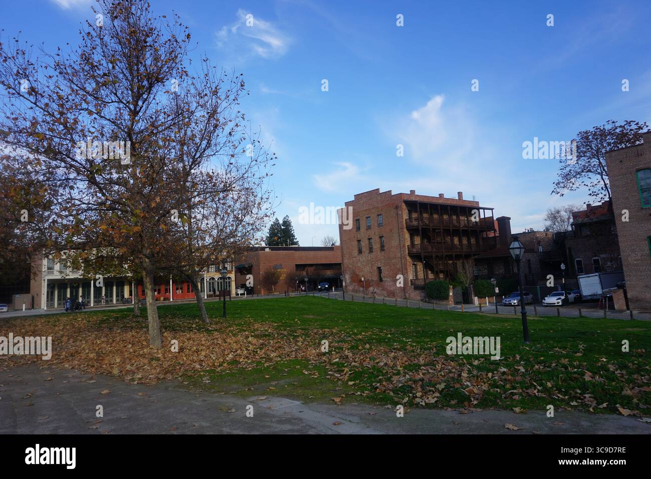 Ein malerischer Blick auf historische Backsteinhäuser und einen Park mit Herbstlaub in Old Sacramento, Kalifornien. Stockfoto