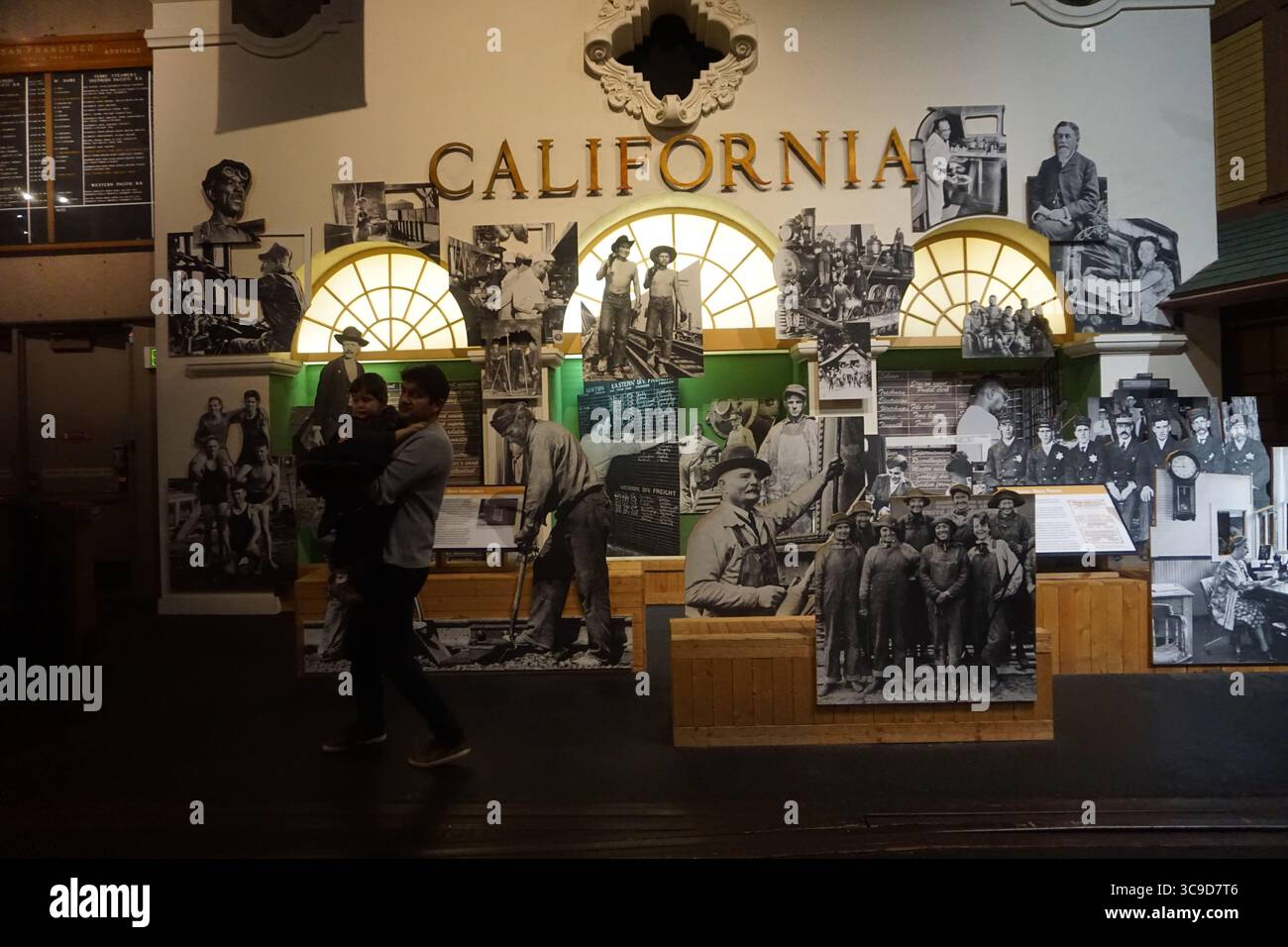 Die Ausstellung, eine Ausstellung mit der Aufschrift „CALIFORNIA“ mit Vintage-Fotos von Arbeitern und Eisenbahnbauern, unterstreicht die Rolle der Eisenbahn bei der Entwicklung/Auszeichnung. Stockfoto