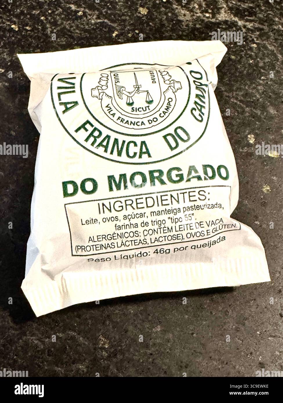 Traditionelles azoranisches Gebäck „Queijadas do Morgado“ aus Vila Franca do Campo, einzeln verpackt in Markenpapier. - Smartphone-aufgenommenes Stockfoto