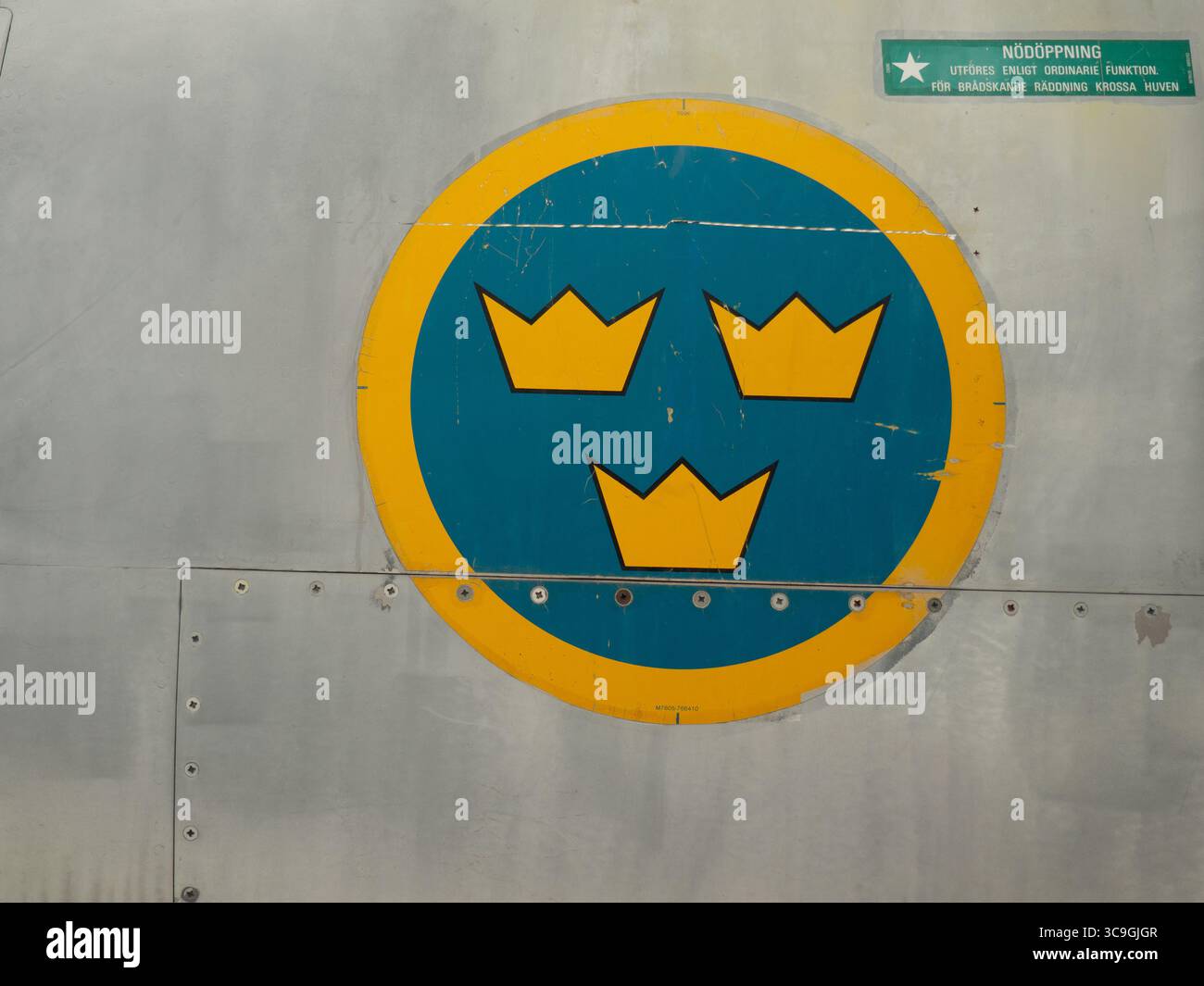 Nahaufnahme des schwedischen Luftwaffenroundels mit Tre Kronor-Insignien, die auf dem Flugzeugrumpf aus Metall gemalt sind, Detail des Militärjets Stockfoto