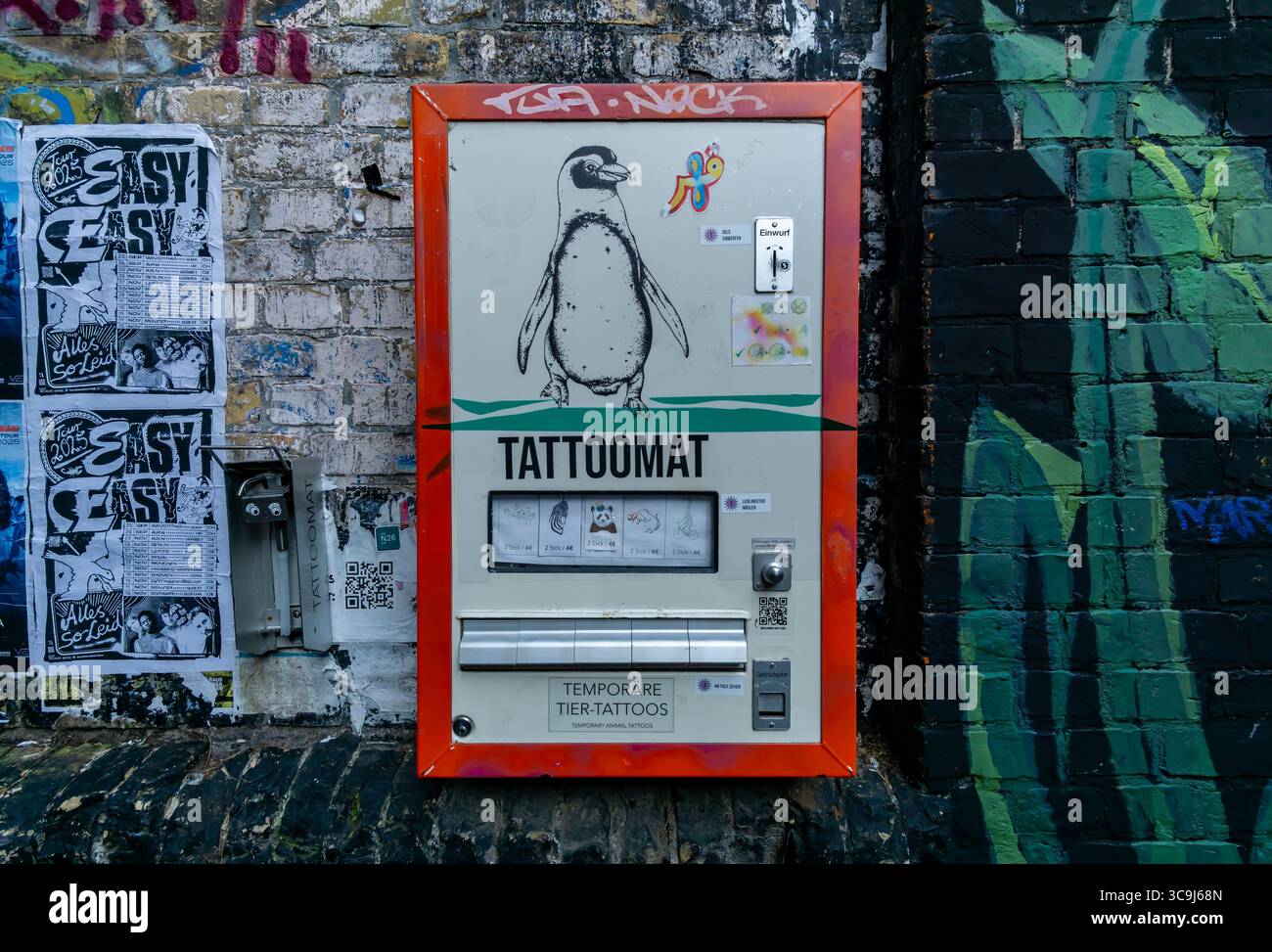 Tattoomat oder Tattooautomat mit Tiermotiven auf Graffiti-bedeckten Wänden in Berlin Friedrichshain. Stockfoto