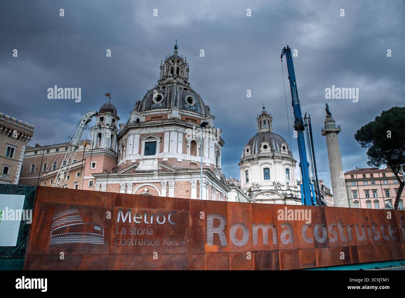 ROM, ITALIEN - 15. JANUAR 2025: Vor den Kuppeln von Santa Maria di Loreto steht eine Baubeschilderung zur Förderung der U-Bahn-Linie Rom C Stockfoto