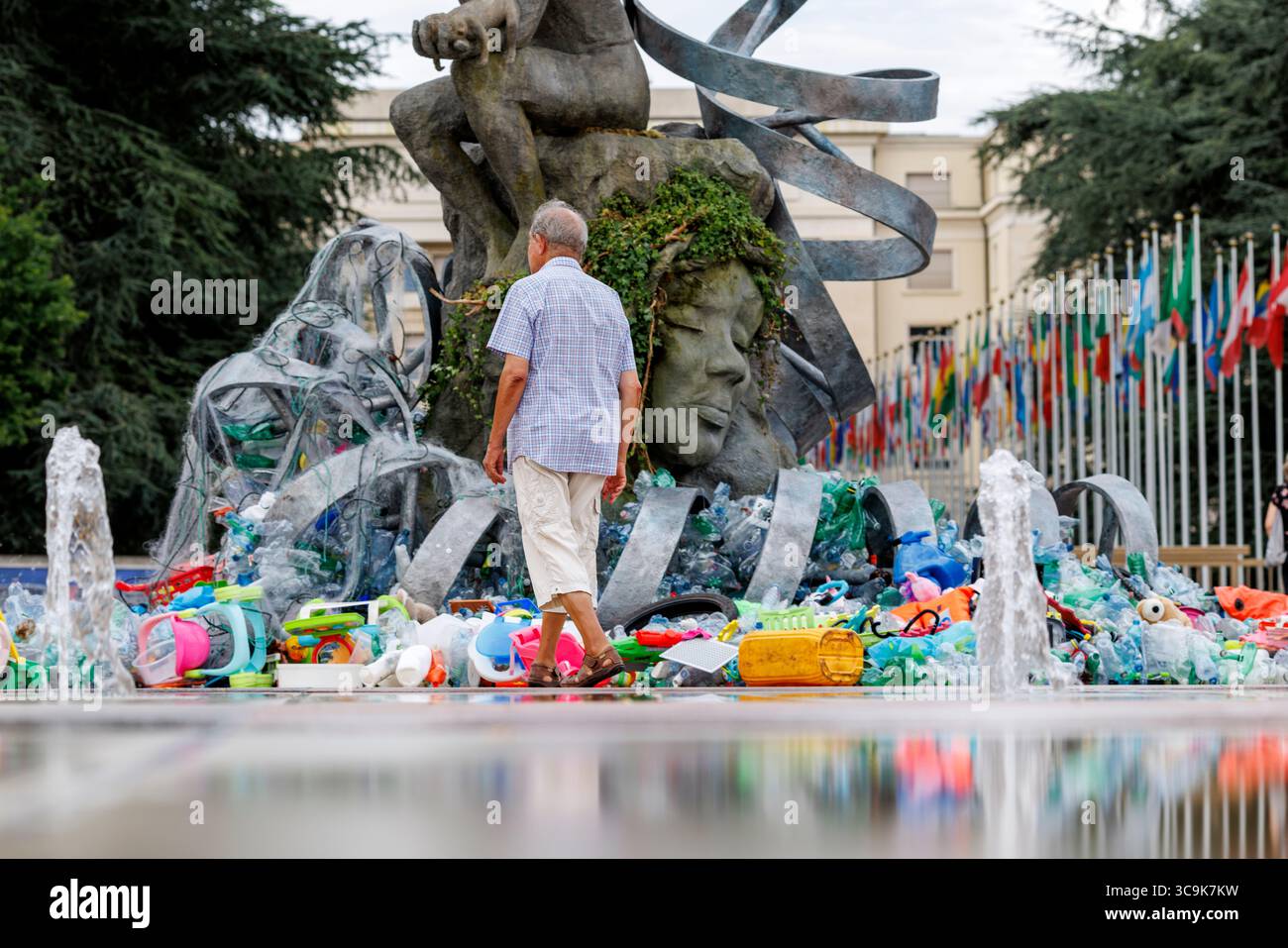 Der Umweltkünstler Benjamin von Wong und seine Installation „The Thinker's Burde“ vor dem Hauptquartier der Vereinten Nationen in Genf. Die Installation wurde in Zusammenarbeit mit der Minderoo Foundation, SLS Illusions und mit der Hilfe von einem Dutzend Freiwilligen durchgeführt. Während der Verhandlungswoche um den Global Plastic Treaty wird die Skulptur langsam in Plastikmüll verwickelt sein. Quelle: Orjan Ellingvag/Alamy Live News Stockfoto
