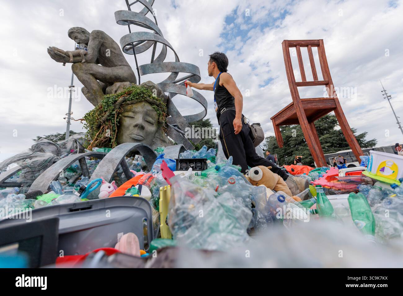 Der Umweltkünstler Benjamin von Wong und seine Installation „The Thinker's Burde“ vor dem Hauptquartier der Vereinten Nationen in Genf. Die Installation wurde in Zusammenarbeit mit der Minderoo Foundation, SLS Illusions und mit der Hilfe von einem Dutzend Freiwilligen durchgeführt. Während der Verhandlungswoche um den Global Plastic Treaty wird die Skulptur langsam in Plastikmüll verwickelt sein. Quelle: Orjan Ellingvag/Alamy Live News Stockfoto