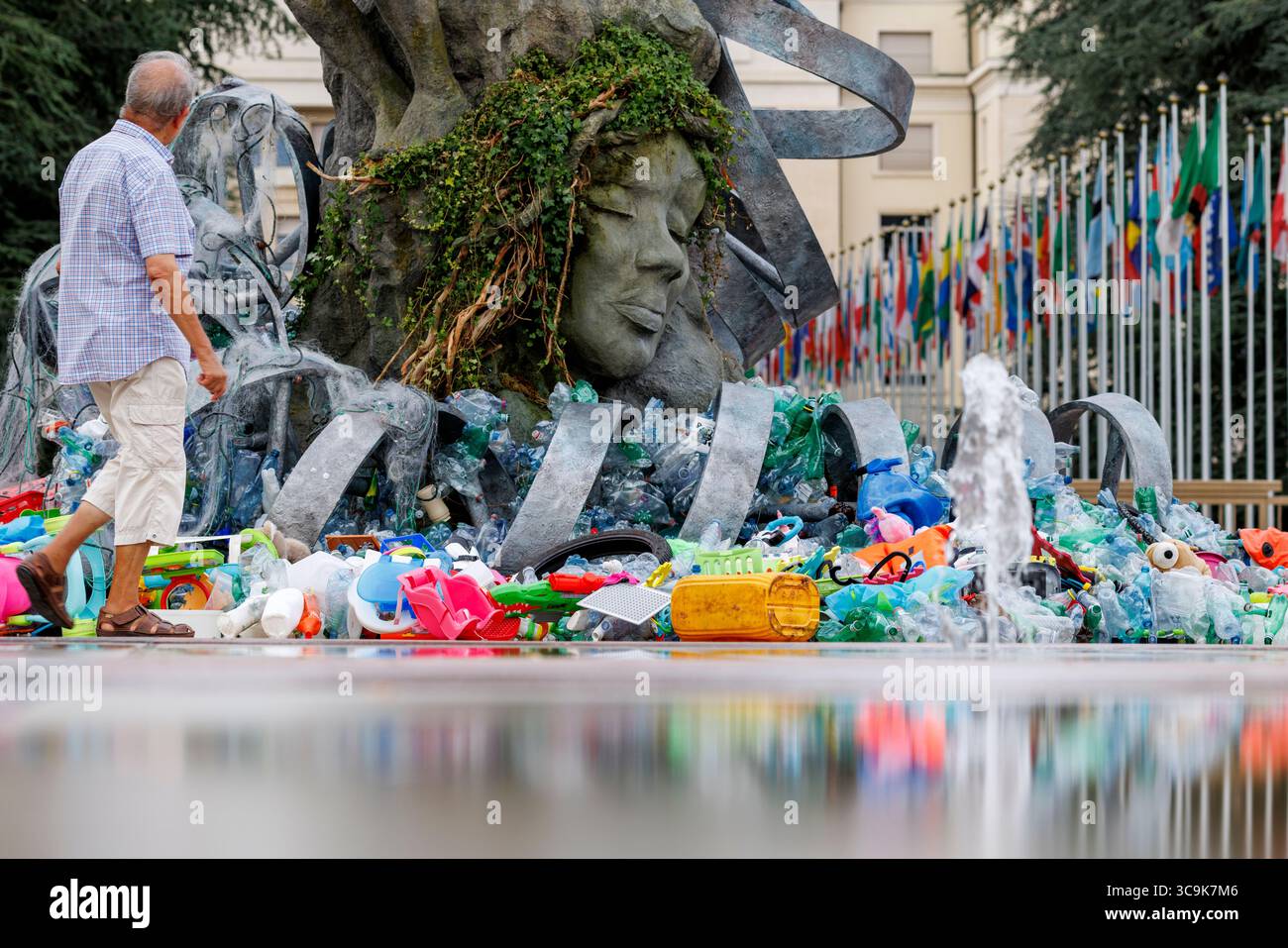 Der Umweltkünstler Benjamin von Wong und seine Installation „The Thinker's Burde“ vor dem Hauptquartier der Vereinten Nationen in Genf. Die Installation wurde in Zusammenarbeit mit der Minderoo Foundation, SLS Illusions und mit der Hilfe von einem Dutzend Freiwilligen durchgeführt. Während der Verhandlungswoche um den Global Plastic Treaty wird die Skulptur langsam in Plastikmüll verwickelt sein. Quelle: Orjan Ellingvag/Alamy Live News Stockfoto