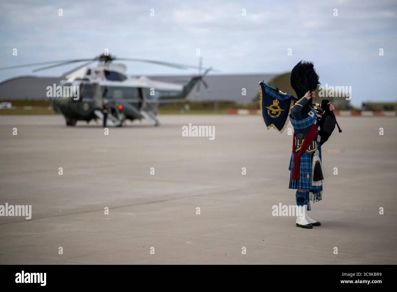 Ein schottischer Dudelsackpiper spielt auf dem Rollfeld, während Marine One sich auf den Abflug am Flughafen Glasgow Prestwick während Präsident Trumps Besuch in Schottland 2025 vorbereitet. Juli 2025. Bild mit freundlicher Genehmigung des Weißen Hauses. Stockfoto