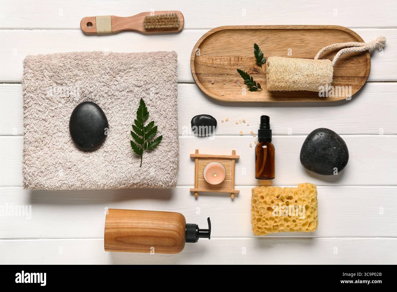 Komposition mit Spa-Steinen und Badaccessoires auf weißem Holzhintergrund Stockfoto
