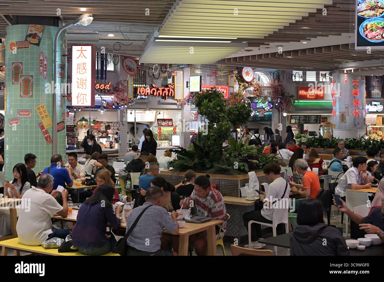 Hektische Mittagsmenschen in einem Food Court in einem High-End-Einkaufszentrum im Herzen von Bangkok, das eine große Auswahl an asiatischen und internationalen Gerichten bietet Stockfoto
