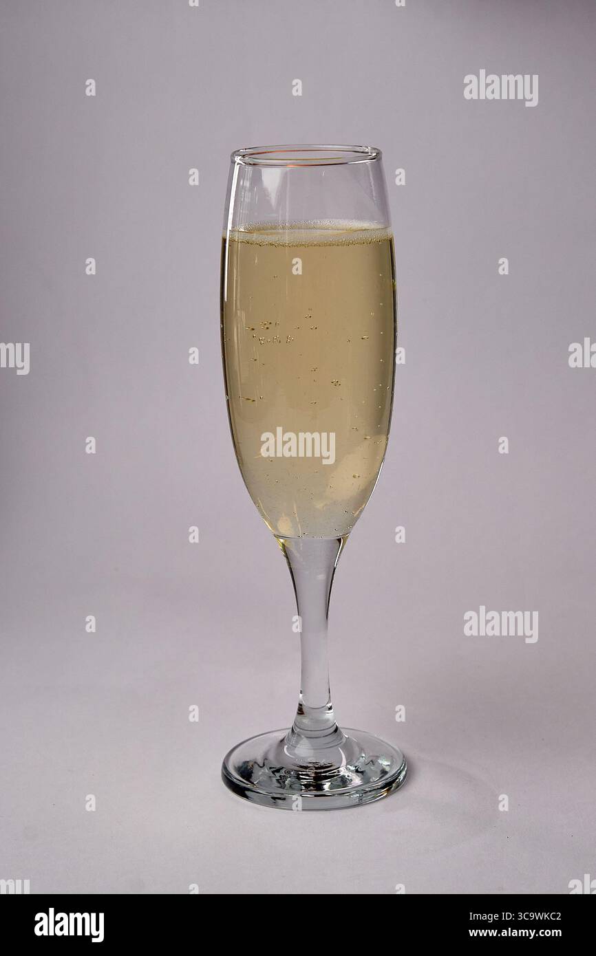 Eine gefüllte Champagnerflöte aus nächster Nähe mit prickelnden Blasen in einem erfrischend frischen Getränk, bereit für Feiern und Toastmomente. Stockfoto