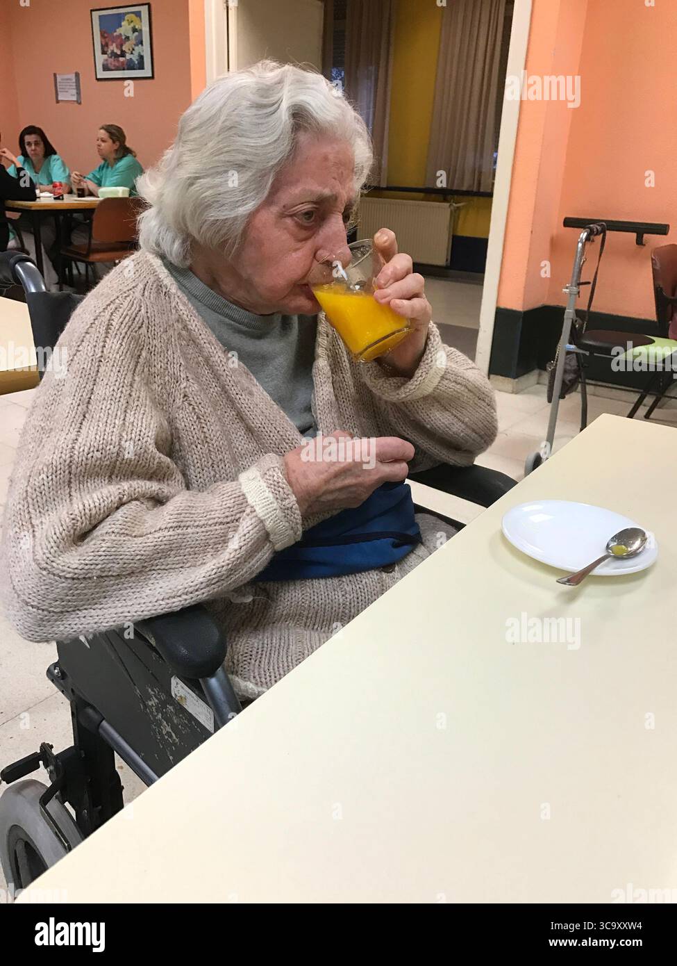 Alte Dame ein Glas Orangensaft trinken. Stockfoto