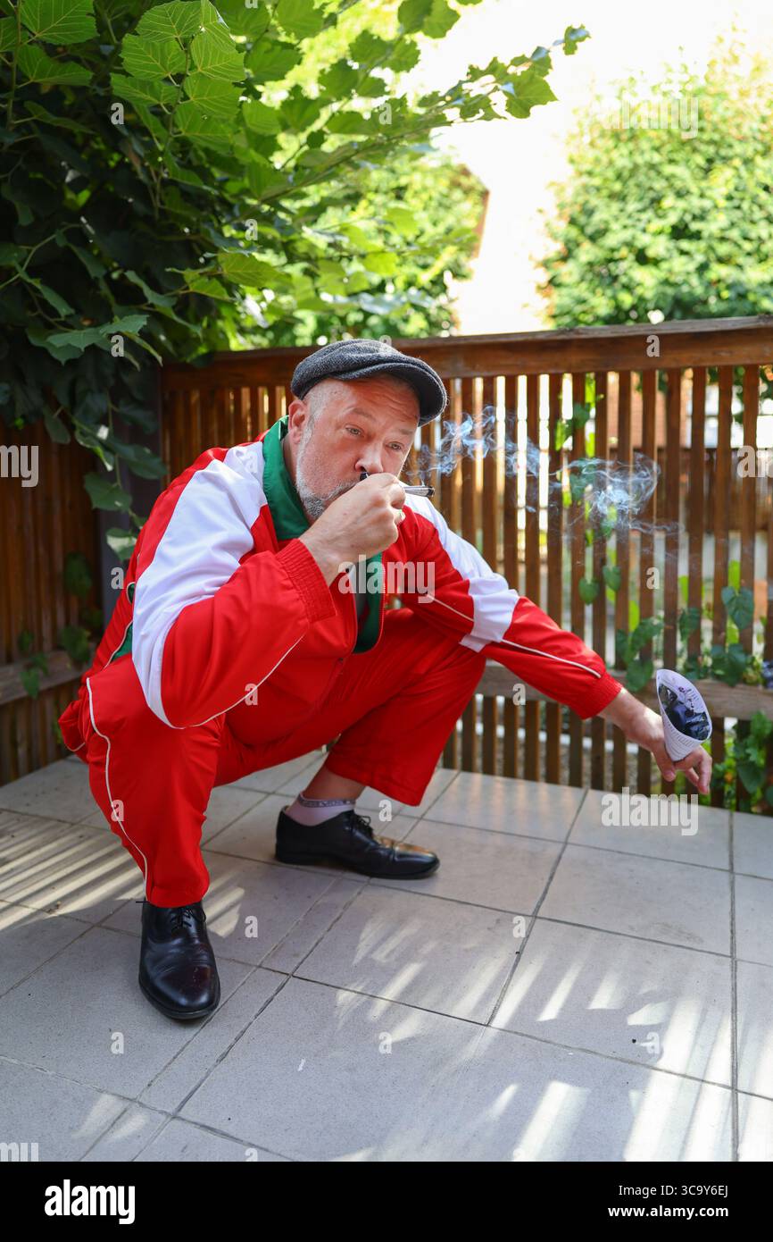 Retro-Street-Fashion-Porträt eines Reifen Mannes im Trainingsanzug, der eine coole rebellische Stimmung ausdrückt. Stockfoto