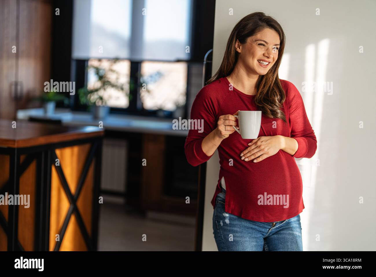 Schwangere Frau, die Entspannung mit einer warmen Tasse Tee praktiziert, Selbstpflege und Wellness zu genießen. Stockfoto