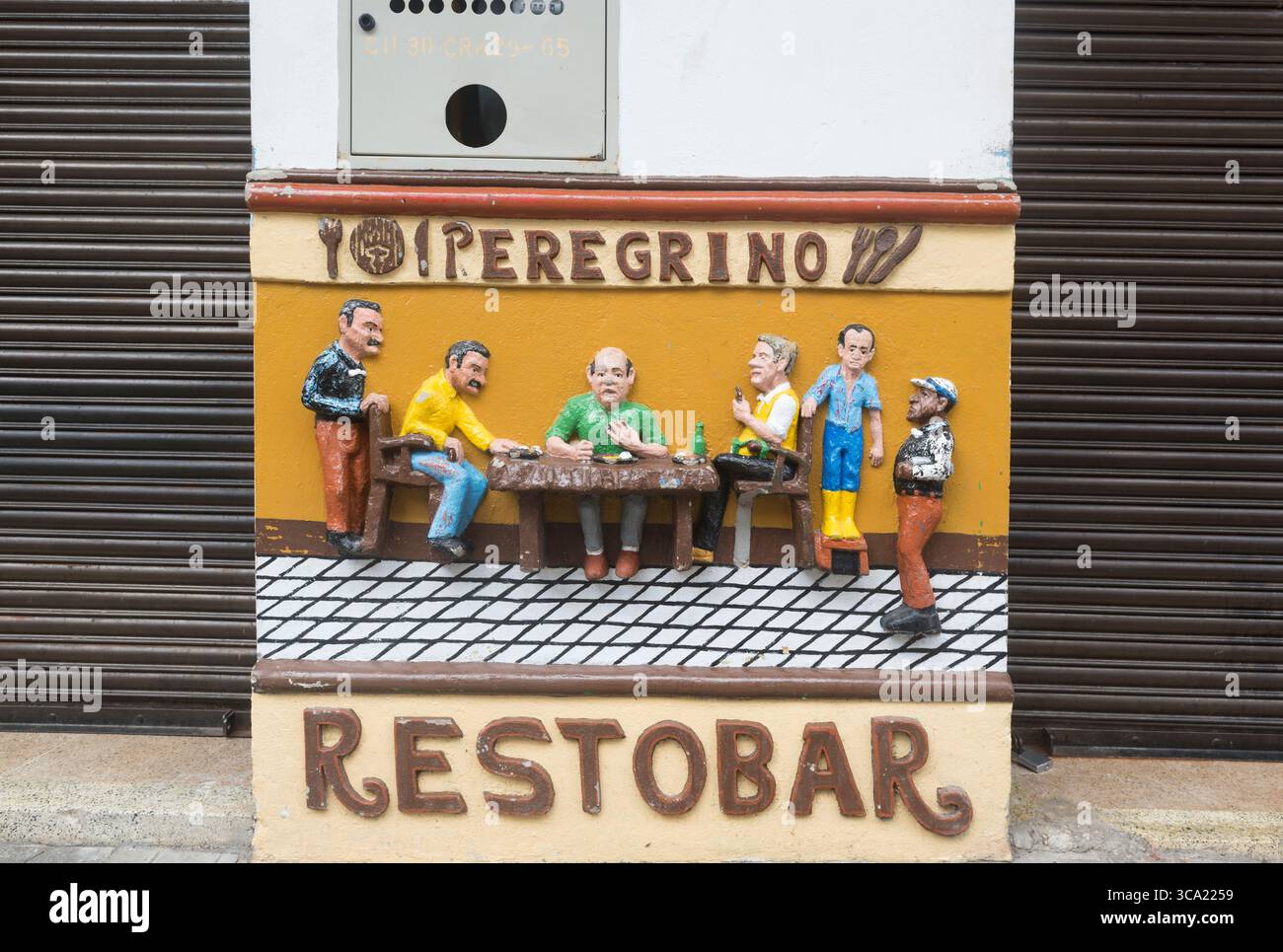 Lustig dimensioniertes Werbebild von Kunden, die an einem Tisch in einem Restaurant/Bar in Guatapé, Antioquia Department, Kolumbien essen Stockfoto