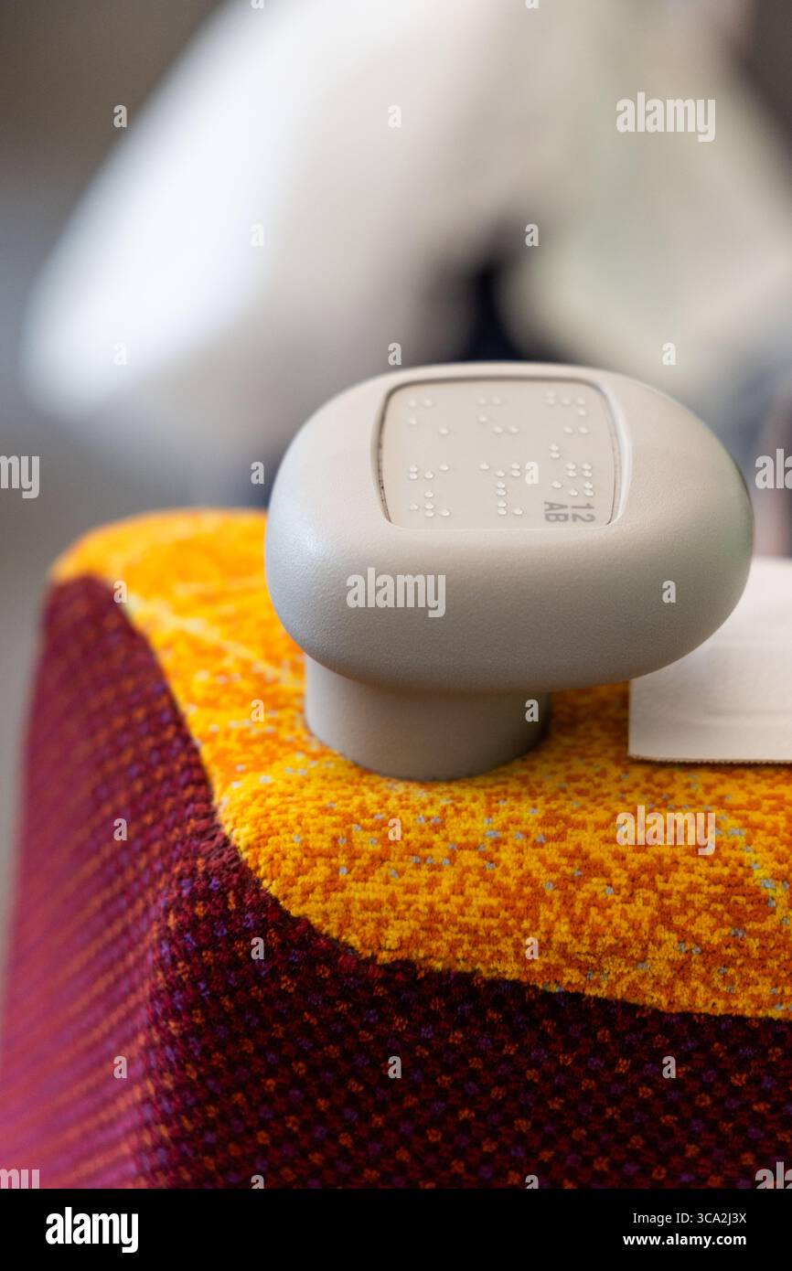 Blindenschrift-Code auf dem Sitzknopf aufgedruckt, damit Sehbehinderte ihren Sitz im öffentlichen Zug finden können Stockfoto