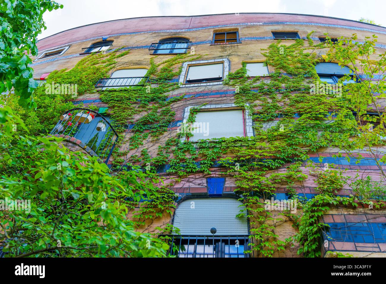 Farbenfrohe Fassade des Wohnkomplexes Waldspirale, geschmückt mit Grün, innovativem architektonischem Design und lebhaften Farben in Darmsta Stockfoto