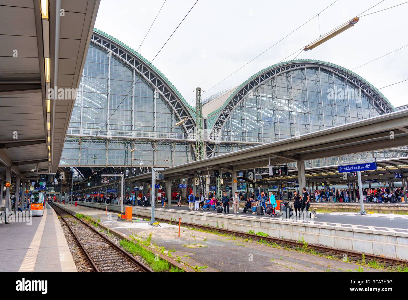 Frankfurt, Deutschland - 10. Juni 2025: Außenansicht des Frankfurter Hauptbahnhofs mit großen Glaskuppeln, belebten Bahnsteigen und lebhaften Menschenmassen unter der Decke Stockfoto