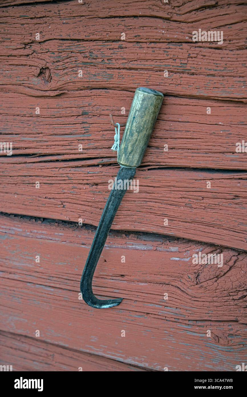 Ein Stück hängt an einer roten Holzwand. Stockfoto