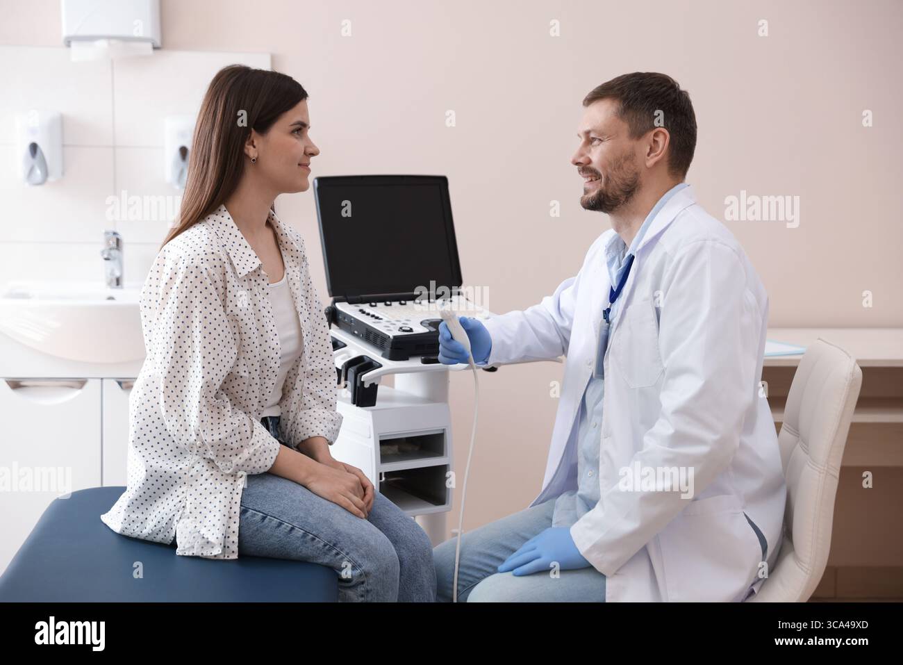 Sonographin berät Frau vor ihrer Ultraschalluntersuchung in der Klinik Stockfoto