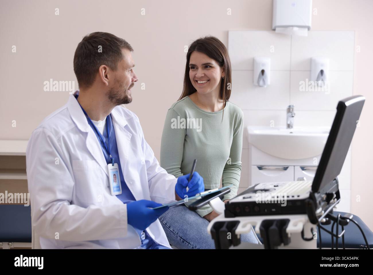 Sonographin berät Frau vor ihrer Ultraschalluntersuchung in der Klinik Stockfoto