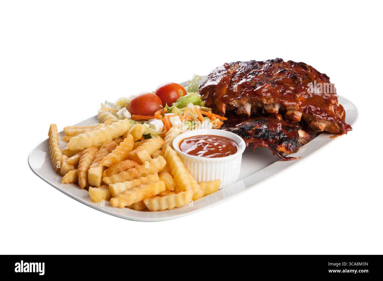 Rippchen mit rauchiger Barbecue-Sauce, serviert mit knusprigen goldenen Pommes Frites und einem frischen Gartensalat – das ultimative Wohlfühlfest Stockfoto